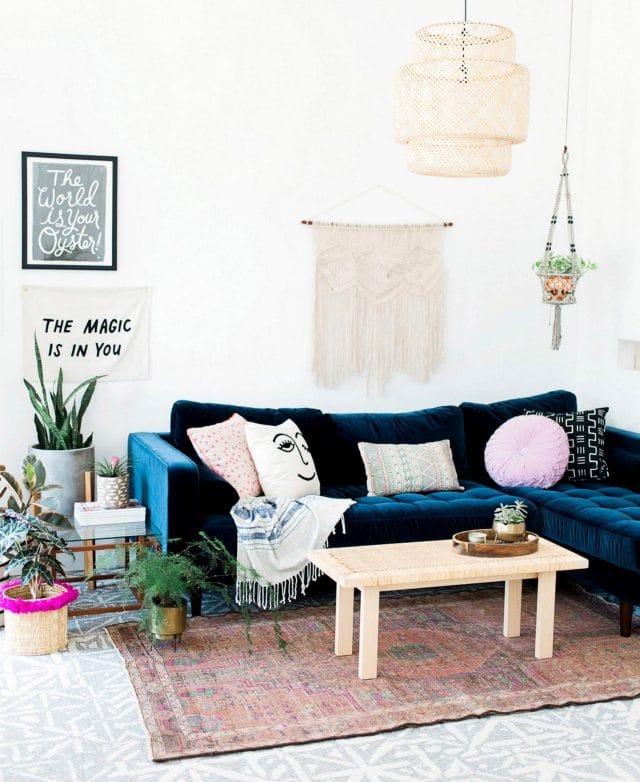 A blue velvet sofa looks beautiful in blogger Oh So Beautiful Paper's living room. 