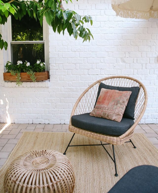 A wicker Aeri Lounge Chair is shown against a white wall