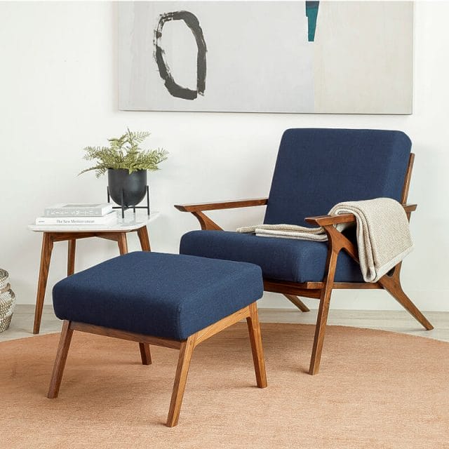 A blur chair on a brown rug in a modern living room.